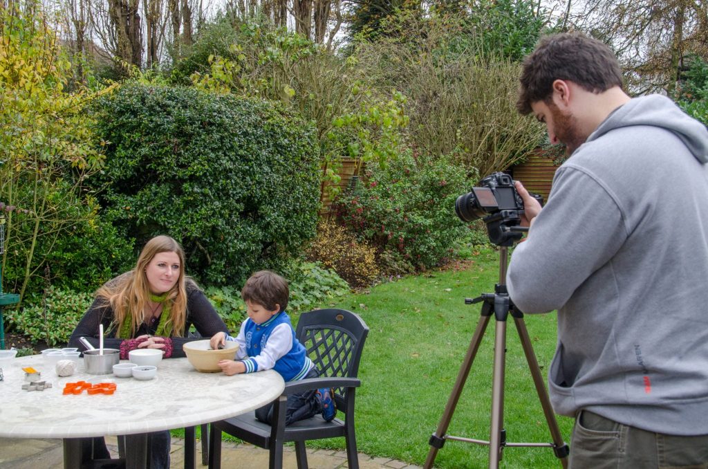 Michael filming Laura and Tiago making bird seed cake in the wildlife garden