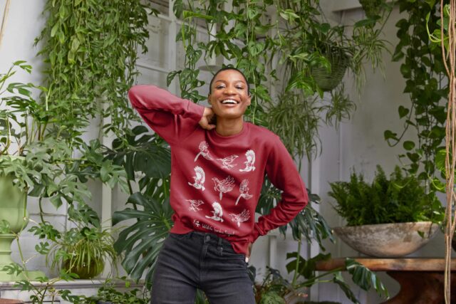 Woman wearing a red jumper with birds on